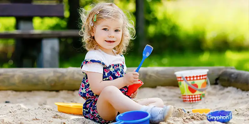 Young girl playing in a sandboc
