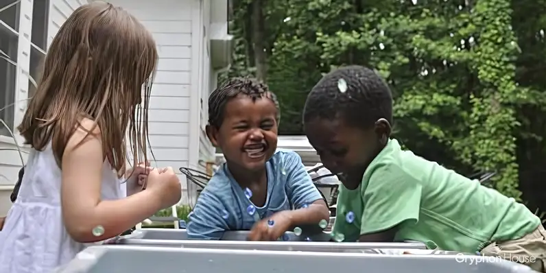 Chilren playing in water tubs outside