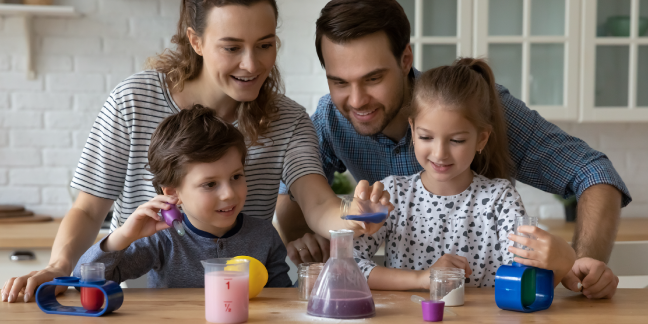 Two parents and two children playing with a children's science set