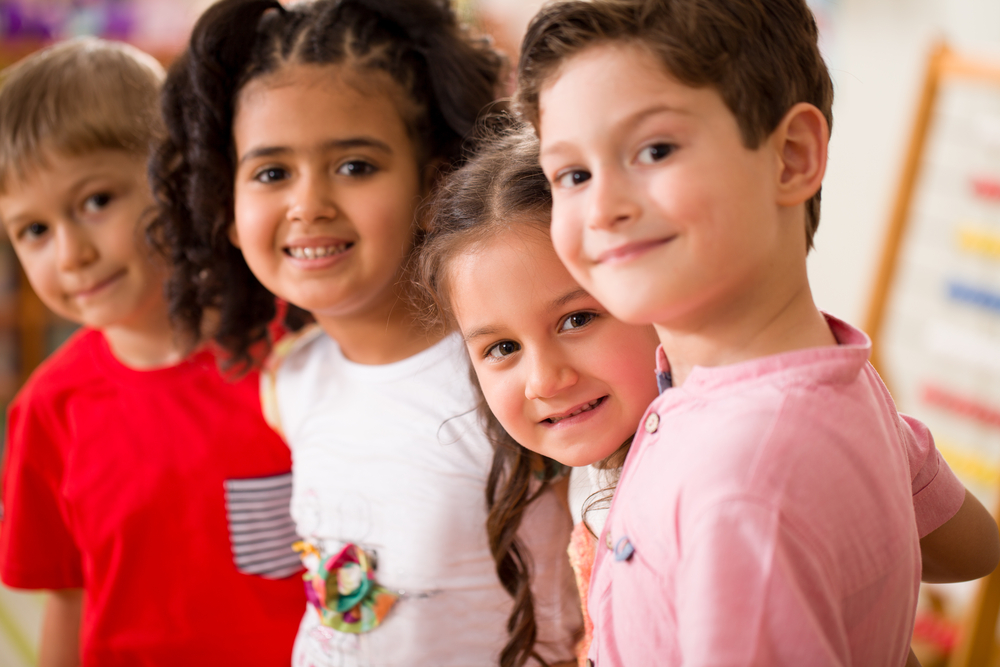 four kids smiling at the camera.